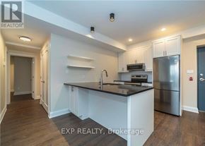 Ottawa apartment for rent - A kitchen with white cabinets and a black countertop.