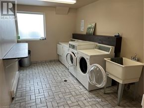 London East (East D) condo for rent - A laundry room with a washer and dryer, sink, and trash can.