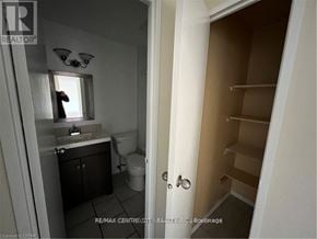 London East (East D) condo for rent - A bathroom with a toilet, sink, and mirror.