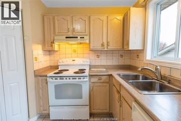 Windsor apartment for rent - A kitchen with a white stove and wooden cabinets.