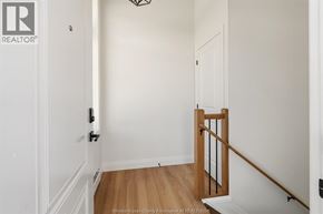 Amherstburg townhouse for rent - A hallway with a wooden railing and white walls.