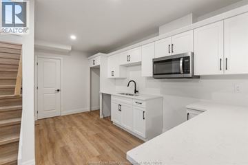 Amherstburg townhouse for rent - A kitchen with white cabinets and a wooden floor.