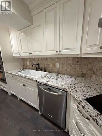 Mississauga (Mineola) apartment for rent - A kitchen with white cabinets and a granite countertop.