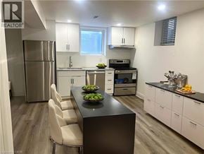 Kitchener apartment for rent - A modern kitchen with a black island and white cabinets.