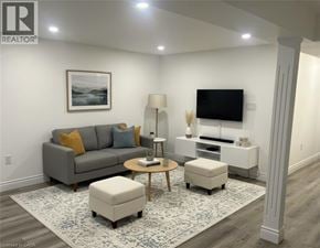 Kitchener apartment for rent - A living room with a grey couch, a coffee table, a lamp, a TV, and a framed picture on the wall.