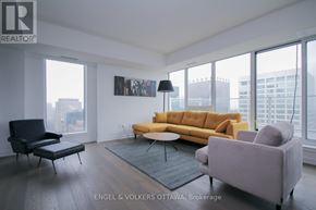 Ottawa condo for rent - A living room with a yellow couch and a black chair.