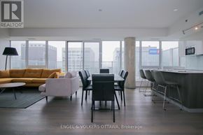 Ottawa condo for rent - A modern living room with a yellow sofa and a dining table with chairs.
