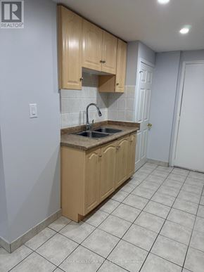 Mississauga (Churchill Meadows) apartment for rent - A kitchen with wooden cabinets and a tiled floor.