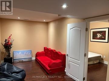Markham (Wismer) apartment for rent - A living room with a red couch and a black chair.