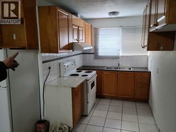 Vancouver apartment for rent - A kitchen with a white stove top oven and a white dishwasher.