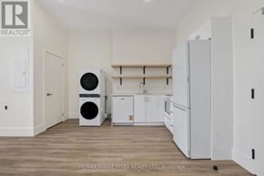 Cobourg apartment for rent - A white kitchen with a washer and dryer in a brokerage.