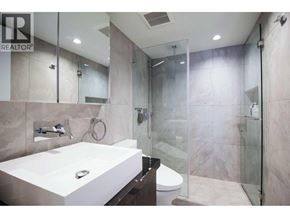 Vancouver apartment for rent - A modern bathroom with a walk-in shower and a large mirror above the sink.