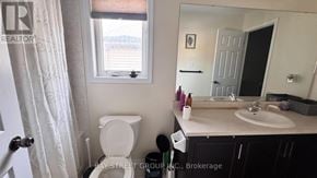 Niagara Falls (Brown) apartment for rent - A bathroom with a toilet, sink, and mirror.