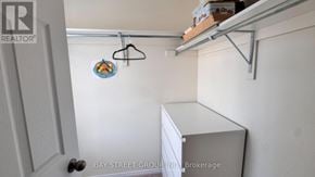 Niagara Falls (Brown) apartment for rent - A small closet with a hanger and a brokerage sign.