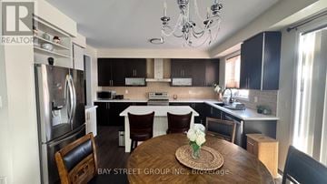 Niagara Falls (Brown) apartment for rent - A kitchen with a refrigerator, a dining table with chairs, and a chandelier.