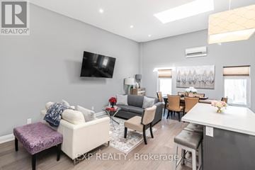 Niagara Falls (Dorchester) apartment for rent - A living room with a white couch and a flat screen TV mounted on the wall.