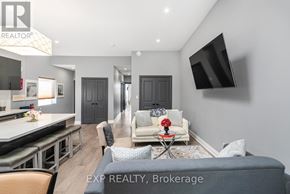 Niagara Falls (Dorchester) apartment for rent - A modern living room with a grey sofa and a television mounted on the wall.