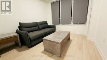 Hamilton (Kirkendall) condo for rent - A living room with a grey couch and a wooden coffee table.