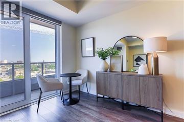 Kitchener condo for rent - A living room with a table, chairs and a cabinet.