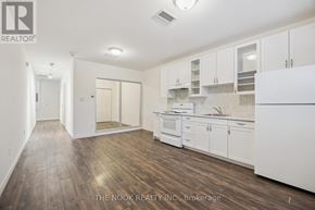 Port Hope apartment for rent - A kitchen with white cabinets and a wooden floor.
