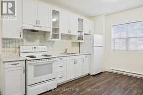 Port Hope apartment for rent - A white kitchen with a stove top oven and a refrigerator.