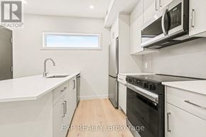 Ottawa multi-family for rent - A modern kitchen with white cabinets and appliances.