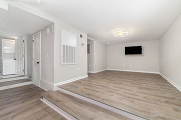 Charlotte apartment for rent - A spacious living room with a television and hardwood flooring.
