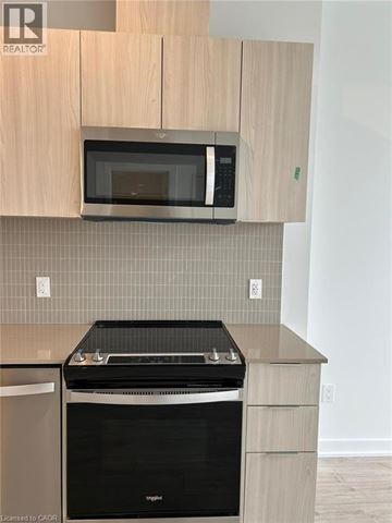 Milton condo for rent - A kitchen with a black oven and microwave above it.