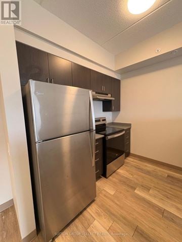 London South (South J) condo for rent - A stainless steel refrigerator in a kitchen with wooden flooring.