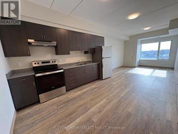 London South (South J) condo for rent - A kitchen with dark brown cabinets and a stainless steel oven.