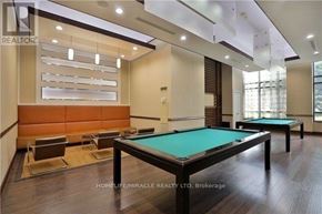 Mississauga (City Centre) condo for rent - A billiards table is in the middle of a room with a pool table and a shelf.