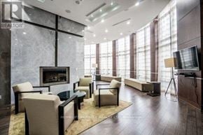 Mississauga (City Centre) condo for rent - A modern living room with a fireplace and a flat screen TV.