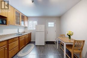Toronto (North Riverdale) apartment for rent - A kitchen with wooden cabinets and a white refrigerator.