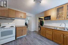 Toronto (North Riverdale) apartment for rent - A kitchen with wooden cabinets and a white stove top oven.