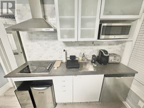 Toronto (Kensington-Chinatown) townhouse for rent - A kitchen with a stove top oven, microwave, and a dishwasher.