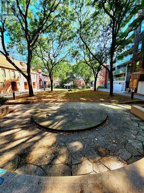 Toronto (Kensington-Chinatown) townhouse for rent - A circular stone patio with trees in the background.