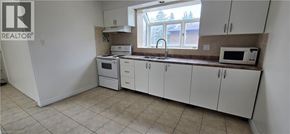 Kitchener apartment for rent - A kitchen with white cabinets and appliances.