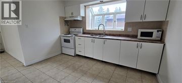 Kitchener apartment for rent - A kitchen with white cabinets and appliances.