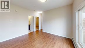 Grande Prairie apartment for rent - A room with wooden floors and white walls, with a doorway leading to another room.
