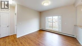 Grande Prairie apartment for rent - A room with a window and wooden floors.
