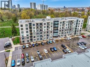 Waterloo condo for rent - A large white building with a parking lot in front of it.