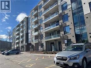 Waterloo condo for rent - A silver Subaru SUV is parked in a parking lot in front of a multi-story apartment building.