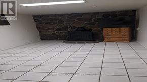 Toronto (West Hill) apartment for rent - A room with a stone wall and a white tile floor.
