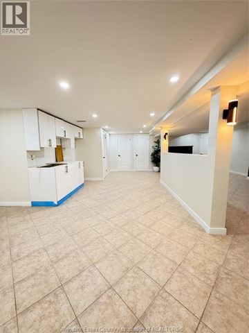 Windsor apartment for rent - A spacious room with a kitchenette and tiled flooring.