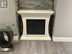 King (Nobleton) apartment for rent - A white fireplace with a glass door in front of a stone wall.