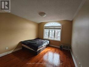 Markham (Wismer) apartment for rent - A bedroom with a bed, a window, and a wooden floor.