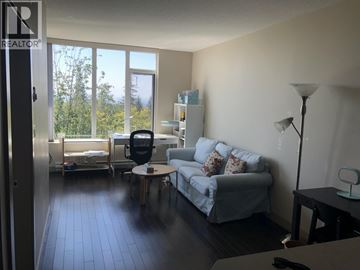 Burnaby apartment for rent - A living room with a grey couch and a black chair.
