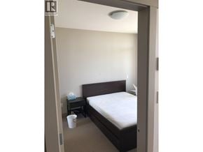 Burnaby apartment for rent - A bedroom with a bed, nightstand, and cup on the floor.