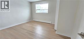 Kitchener apartment for rent - A room with a window and wooden flooring.