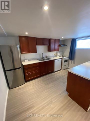 Orillia duplex for rent - A kitchen with wooden cabinets and a stainless steel refrigerator.